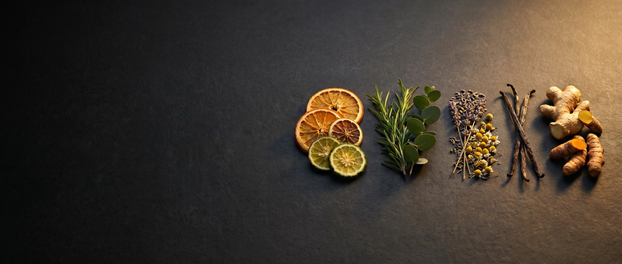 Dried citrus, herbs, lavender, and vanilla arranged on a dark surface.